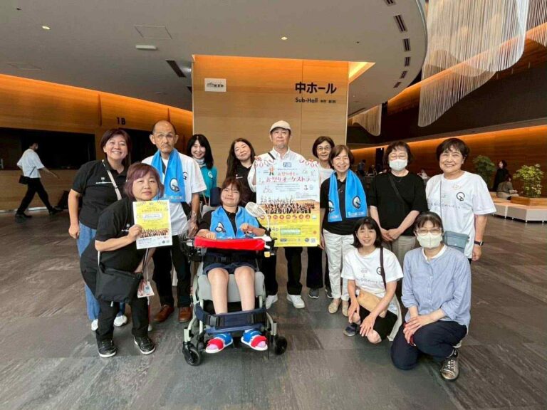やさしい受付スタッフの集合写真で車椅子の女性を含む女性11名と男性2名。